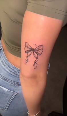 a woman's arm with a tattoo on it that is shaped like a bow