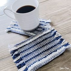 a cup of coffee sitting on top of a table next to a blue and white rug