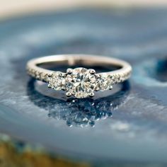 a diamond ring sitting on top of a marble slab