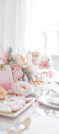 the table is set with pink and white flowers