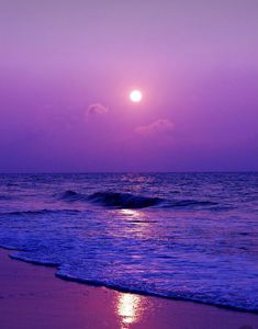 the sun is setting over the ocean with purple hues