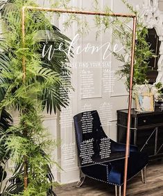 a chair sitting in front of a wall with greenery on it's sides