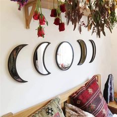 four circular mirrors mounted to the wall above a bed with pillows and blankets on it