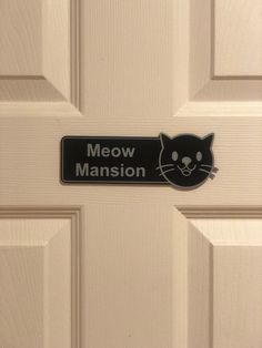 a black and white sign that says meow mansion on it's front door