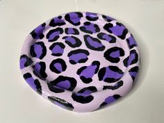 a purple and black leopard print paper plate on a white tablecloth with an animal print pattern