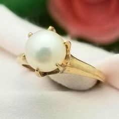 CLASSIC-STYLE 10K Yellow Gold Claw Prong Solitaire Pearl Ring- Beautifully Crafted.  Made in the 1950s. Pearl is the Birthstone for the Month of June. This Ring Would Make a Perfect Birthday Present! This Traditional and Simplistic-Style Ring features a Cultured Pearl that is Uniquely Set with 6 Claw Prongs that Add the Vintage Flair to the Piece. The Contrast Between the Warm Gold Undertones and Pearly White is Absolutely Stunning.  The Pearl measures 6.8mm Round The Band measures 2.3mm in Widt Classic Pearl Ring With Prong Setting For Formal Occasions, Classic Formal Pearl Ring With Prong Setting, Formal Classic Pearl Ring With Prong Setting, Classic Yellow Gold Pearl Ring With Round Band, Classic Round Pearl Ring For Formal Occasions, Classic 14k Gold Pearl Ring, Classic Yellow Gold Collectible Rings, Retro Yellow Gold Round Jewelry, Classic Round Pearl Ring For Anniversary