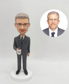 a bobble head with a business man holding a coffee cup