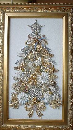 a christmas tree made out of pearls and other things in a gold frame on the wall