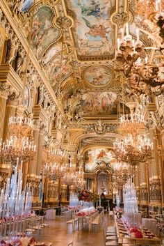 an ornately decorated dining room with chandeliers and paintings on the ceiling,