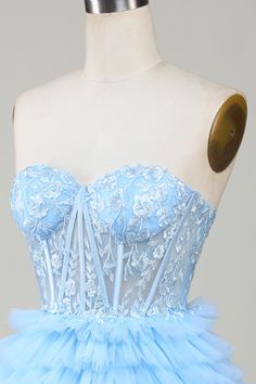 a light blue dress on a mannequin with buttons in the front and back