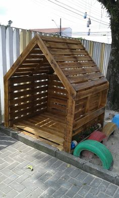 a dog house made out of wooden pallets