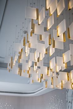 a chandelier hanging from the ceiling in a room with white walls and lights