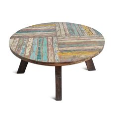 a round wooden table with multicolored paint on the top and two small legs