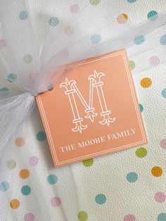 an envelope with the monogrammed m on it sitting on a polka dot blanket