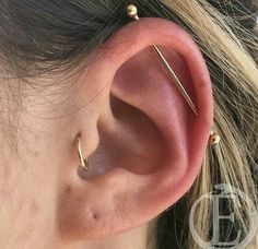 a close up of a person's ear with two piercings on it and one behind the ear