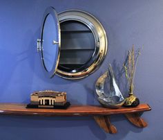 a shelf with a mirror and vases on it next to a wall mounted clock