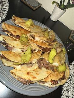 a plate full of pita bread with pickles and cheese on it, sitting on a table