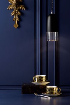 a black and gold table lamp next to a blue wall