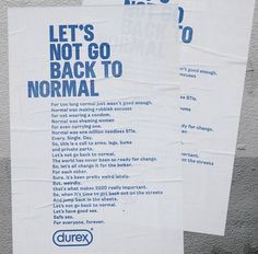 two posters on the side of a building that say let's not go back to normal