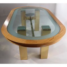 a glass and wood coffee table with gold legs