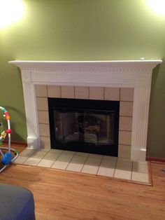 a living room with a fire place in the center and toys on the floor next to it