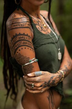 a woman with tattoos on her arms and armbands is posing for the camera