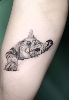 a small cat tattoo on the right thigh, with an eyeball in it's mouth