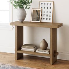 a wooden table topped with books and a vase