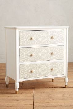 a white dresser sitting on top of a wooden floor