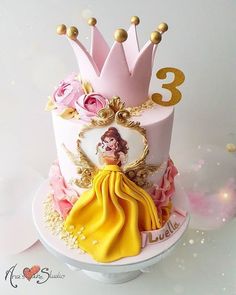 a three tiered cake decorated with princesses and gold numbers on it's sides