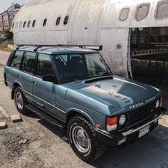 an suv is parked in front of a plane