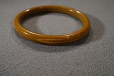 I am offering you this wonderful vintage Bakelite fancy carved, dark colored butterscotch colored Bakelite bangle bracelet (tested positive) It is very dimensional domed, and detailed. There is such intense color saturation to this Bakelite. It is bold and very curvaceous and convex measuring 2 1/2 inches in diameter, and it is a bit under 1/2 inch wide. It has very rounded and curved edges, you will be noticed when wearing this beauty!! The plastics are so popular with Lucite, Bakelite, and cel Brown Bakelite Bangle Bracelet, Brown Carved Bangle Bracelets, Vintage Carved Brown Bracelets, Vintage Brown Carved Bracelets, Vintage Brown Bangle As A Gift, Formal Brown Round Bangle, Bracelet Fancy, The Plastics, Bakelite Bangles