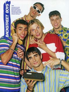 a group of young men standing next to each other in front of a tv advertisement