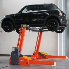 a black truck on top of a lift in a garage