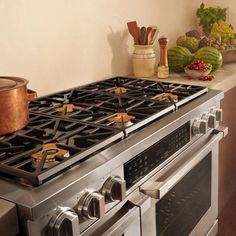 a stove top oven sitting in a kitchen next to a counter with pots and pans on it