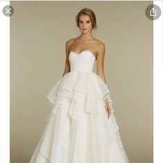 a white wedding dress with ruffles on the skirt