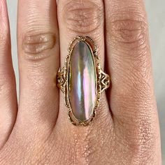 "This gorgeous ring is made of solid 10k yellow gold and a huge section of mother of pearl. Size 10.25 and in good condition. Marked \"10k.\" Thank you for looking! We are a licensed gold and silver buyer in the state of California; all of our items are tested for purity and authenticity. Please let us know if you have any questions or shipping requests!" Gold Mother Of Pearl Anniversary Rings, Gold Mother Of Pearl Rings For Anniversary, Oval Mother Of Pearl Ring With Polished Finish, Formal Oval Mother Of Pearl Rings, Elegant Oval Iridescent Opal Ring, Formal Iridescent Oval Ring, Iridescent Oval Jewelry For Anniversary, Iridescent Oval Jewelry For Anniversaries, Elegant Iridescent Opal Ring For Anniversary