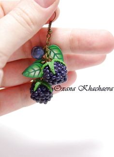 a person is holding some grapes and green leaves in their hand as if they were eating them