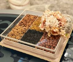 a tray filled with nuts and flowers on top of a table