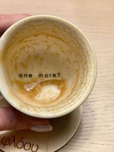 a person holding a coffee cup with the words one more written on it