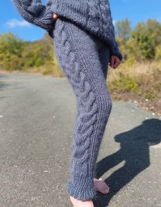 a person standing on the side of a road with their feet up in the air