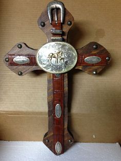 an ornate wooden cross with two horses on the front and one horse on the back