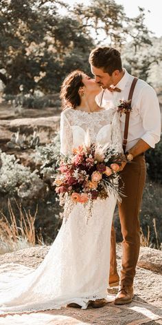 a bride and groom kissing in the desert