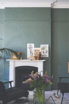 a living room filled with furniture and a fire place under a painting on the wall