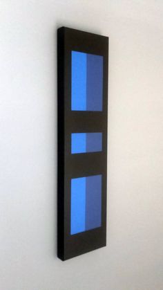 a black and blue wall hanging on a white wall