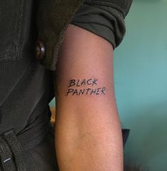 a person with a tattoo that says black panther on their left arm and the word,