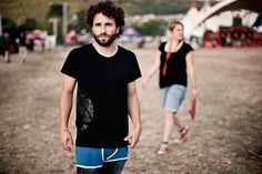 two people are walking in the dirt near each other and one is wearing a black shirt