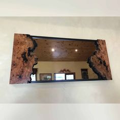 a mirror hanging on the side of a wall next to a wooden floor and ceiling