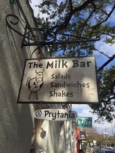 a sign on the side of a building that says the milk bar salads sandwiches shakes