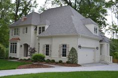 a large white brick house with two garages